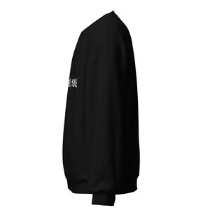 May include: Black sweatshirt with the white text "small talk" printed on the front. The sweatshirt is made of a soft material and has a crew neck. The image shows the side view of the sweatshirt.