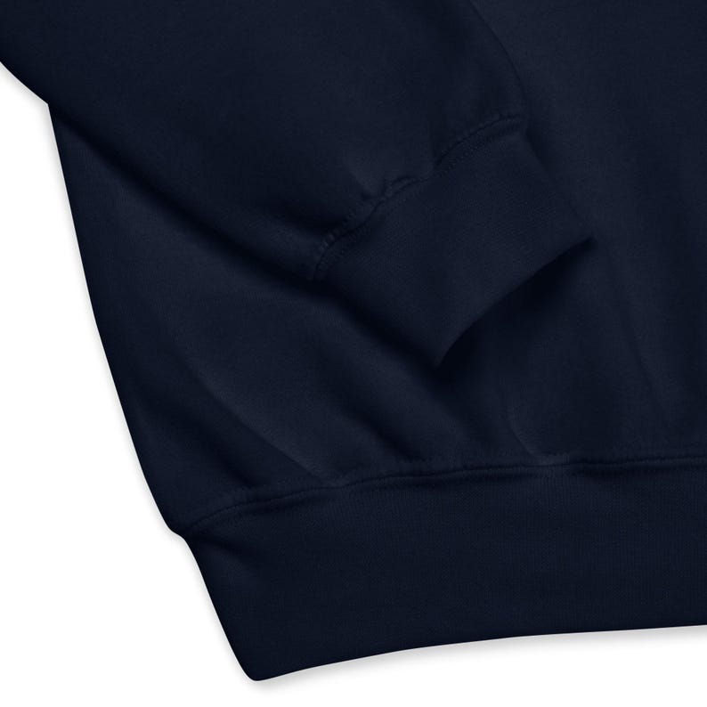 May include: Close-up of a navy blue sweatshirt sleeve and cuff. The fabric appears soft and the cuff is ribbed. The image highlights the texture and construction of the garment, suitable for casual wear.