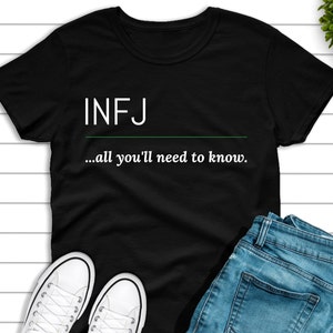May include: Black t-shirt with white text that reads "INFJ...all you'll need to know."