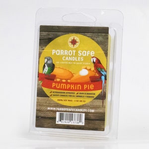 May include: A yellow candle with a pumpkin pie scent in a clear plastic clamshell packaging. The candle is labeled "PARROT Safe CANDLES" and "PUMPKIN PIE". The label also states "VETERINARIAN APPROVED", "ODOR ELIMINATOR", "SAFEST CANDLES FOR ALL ANIMALS + HUMANS", "100% SOY WAX - 3 OZ (85 G)", and "WWW.PARROTSAFECANDLES.COM".