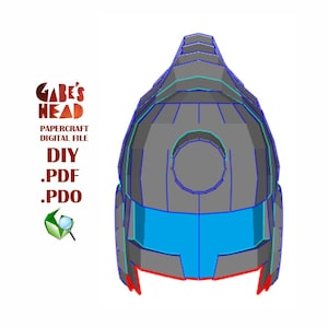 Pode incluir: Um capacete de papel cinza, azul e vermelho com uma abertura circular no topo. O capacete é projetado para ser montado a partir de um arquivo digital. O texto "Gabe's Head" é visível na imagem.