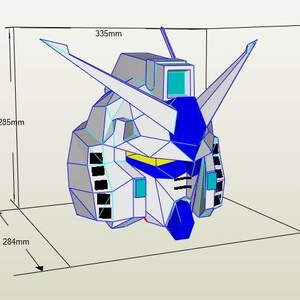 Puede incluir: Un modelo de papel de una cabeza de robot, en blanco y azul, con una franja amarilla sobre los ojos. El modelo mide 335 mm de ancho, 285 mm de alto y 284 mm de profundidad.