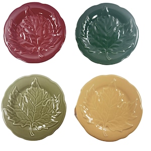 May include: Four ceramic plates in shades of red, green, olive green, and yellow. Each plate features a raised leaf design in the center and a scalloped edge. The plates are round and appear to be for decorative or serving purposes.