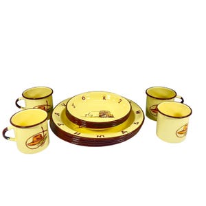 May include: A vintage yellow enamelware dinner set with a Western theme. The set includes plates, bowls, and mugs, all featuring a cowboy hat and branding iron design. The rims are brown. The plates and bowls have brown lettering and numbers.