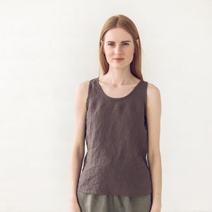 May include: A woman wearing a brown linen tank top and olive green linen shorts.