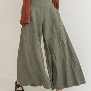 May include: A pair of wide-leg, green linen pants with a high waist and a relaxed fit. The pants are made of a lightweight, breathable fabric and have a flowy silhouette.