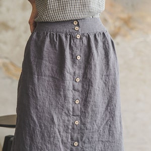 May include: A gray linen skirt with a button-up front and a gingham top.