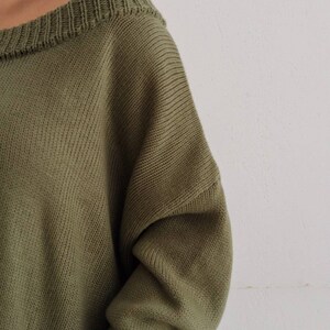 May include: A soft, green off-the-shoulder sweater with a ribbed knit texture.