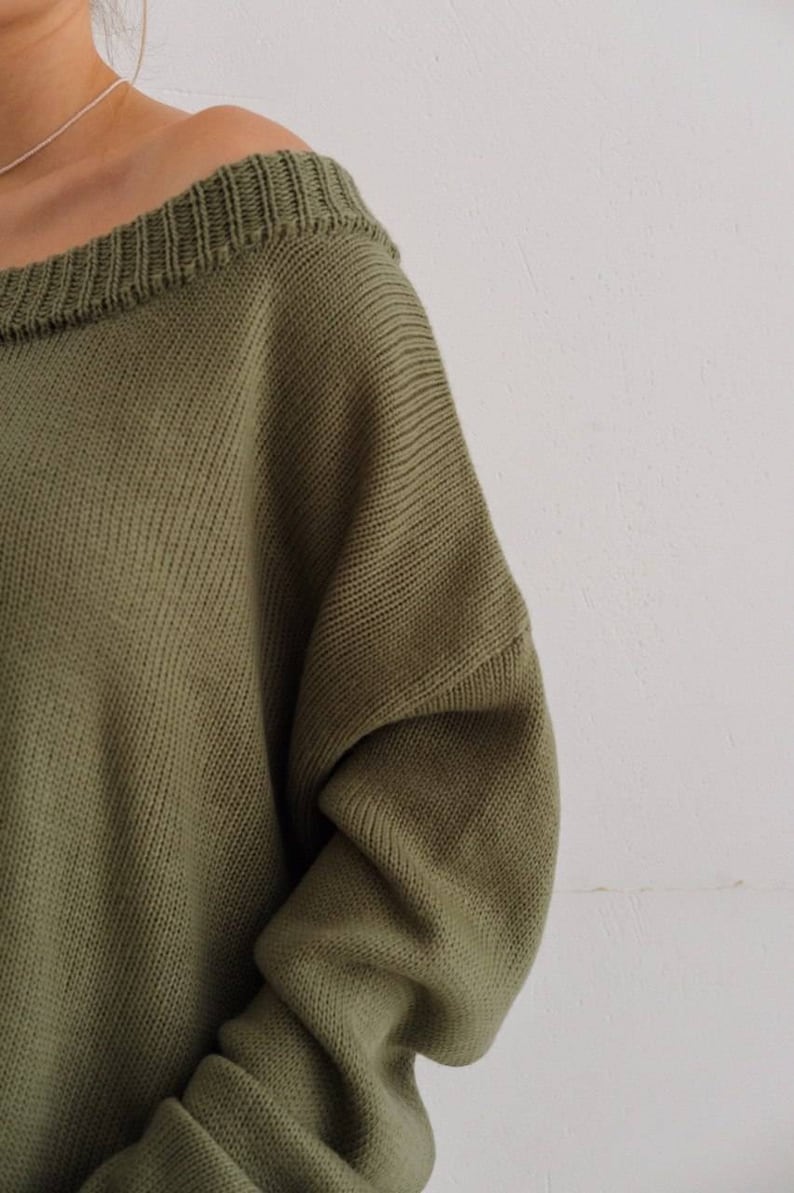 May include: A soft, green off-the-shoulder sweater with a ribbed knit texture.