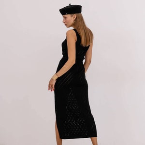 May include: A black sleeveless midi dress with a geometric pattern and a side slit. The dress is paired with a black beret and gold heeled sandals.