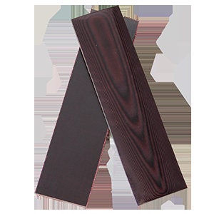 Puede incluir: Dos piezas de madera marrón oscuro para mangos de cuchillo. La madera tiene un patrón de veta rojo oscuro.