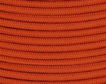 May include: A spool of orange paracord, a type of strong nylon rope often used for crafting and survival purposes.