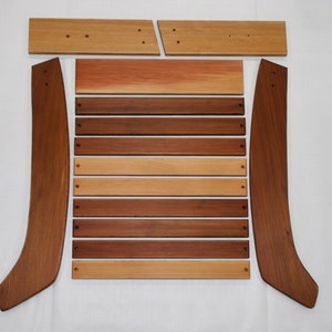 May include: A set of wooden chair parts, including two curved back pieces, a seat back, and eight slats. The wood is a mix of light and dark brown tones.