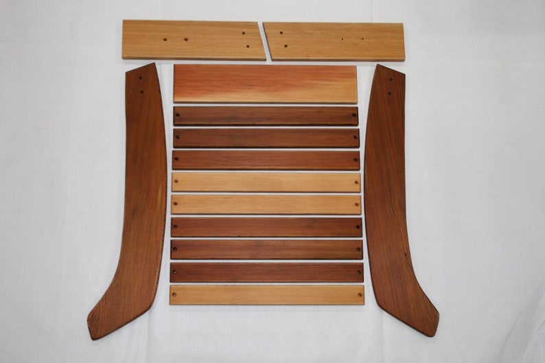May include: A set of wooden chair parts, including two curved back pieces, a seat back, and eight slats. The wood is a mix of light and dark brown tones.