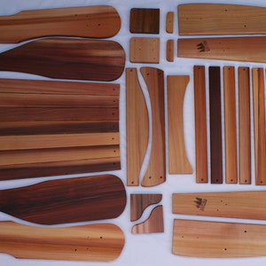 May include: A set of wooden chair parts, including the back, seat, and legs. The pieces are made of cedar wood and are ready to be assembled.