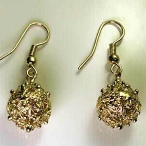 Könnte beinhalten: Ein Paar goldene Ohrhänger mit einem runden, verzierten Design. Die Ohrringe haben einen einfachen Hakenverschluss.