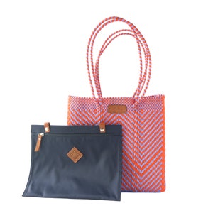 May include: A woven tote bag with a chevron pattern in orange and purple. The bag has a matching zippered pouch.