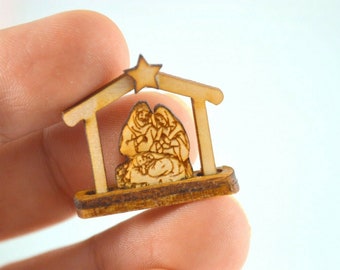 May include: A small wooden nativity scene with a star on top. The scene depicts Mary, Joseph, and baby Jesus.
