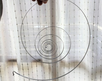 Puede incluir: Una espiral de metal plateado con múltiples círculos concéntricos, creando un efecto visual hipnótico.