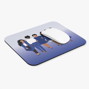 May include: A rectangular mousepad with a gradient blue background and an illustration of five figures in various shades of blue, white, and tan. A white computer mouse rests on the pad.