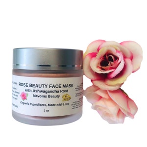 May include: A silver jar with a pink lid containing a rose beauty face mask with ashwagandha root. The jar is labeled "Rose Beauty Face Mask with Ashwagandha Root Navoms Beauty Organic Ingredients, Made with Love 2 oz".