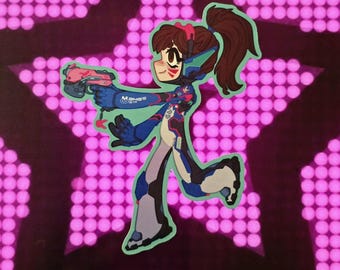 May include: A sticker featuring a cartoon character in a blue and white futuristic outfit, holding a pink gun. The character has brown hair in a ponytail and is set against a background of pink lights. The word "Momo's" is visible on the character's arm.