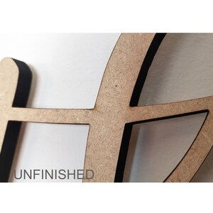 May include: Unfinished wooden cutout of a peace sign with a black border.