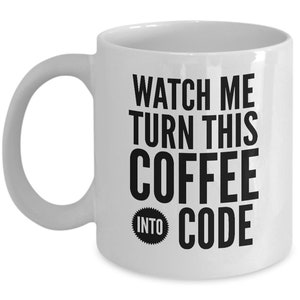 May include: White ceramic coffee mug with a curved handle. The mug features the text "WATCH ME TURN THIS COFFEE INTO CODE" in bold black letters. The words "INTO CODE" are in a starburst design.