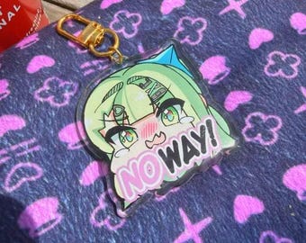 Puede incluir: Un llavero acrílico transparente con un personaje de estilo anime con cabello verde y el texto "NO WAY!" en rosa. El llavero tiene un cierre dorado y descansa sobre una tela azul estampada con formas rosas.