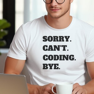 Op de afbeelding: Een wit T-shirt met zwarte tekst die "SORRY. CAN'T. CODING. BYE." zegt.