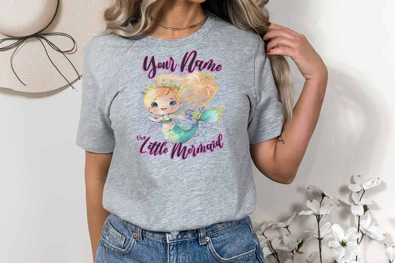 May include: Gray t-shirt with a cartoon mermaid illustration and the text "Your Name the Little Mermaid".