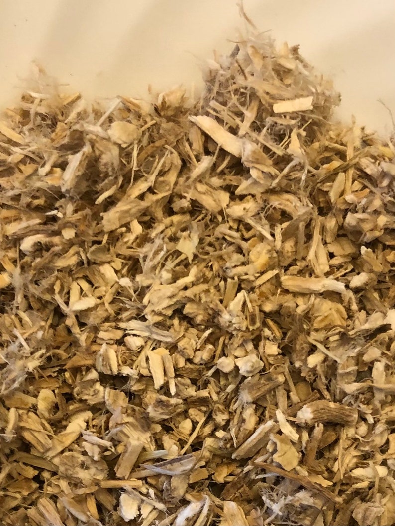 May include: Close-up of a pile of light brown wood chips and fibers. The chips vary in size and shape, with some appearing like small pieces of wood and others like shredded fibers. The overall texture is rough and natural.