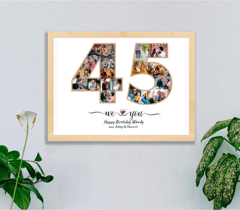 May include: A framed photo collage in a light wood frame. The collage is in the shape of the number 45, filled with various photos. Below the number is the text "we ❤️ you" and "Happy Birthday Wendy" with names.