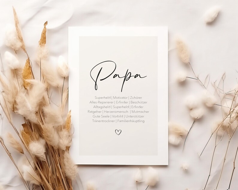 May include: A framed print with the word "Papa" in elegant script. Below, a list of qualities such as "Super Hero" and "Motivator" are listed. The print is surrounded by dried beige ornamental grasses.
