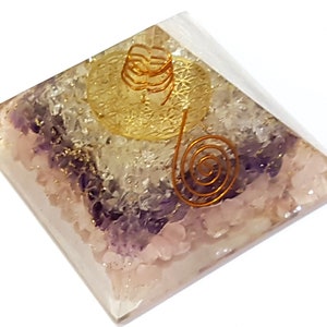 May include: A clear crystal pyramid with a gold wire spiral design. The pyramid is made of clear quartz, rose quartz, and amethyst crystals.