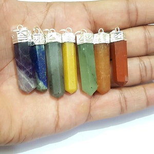 May include: Seven chakra crystal point pendants with silver caps. The crystals are amethyst, lapis lazuli, green aventurine, citrine, green aventurine, carnelian, and red jasper.