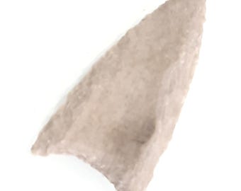 May include: A light tan arrowhead with a triangular shape. The stone tool has a rough, textured surface and a pointed tip, likely used for hunting or warfare. The arrowhead is isolated against a white background.