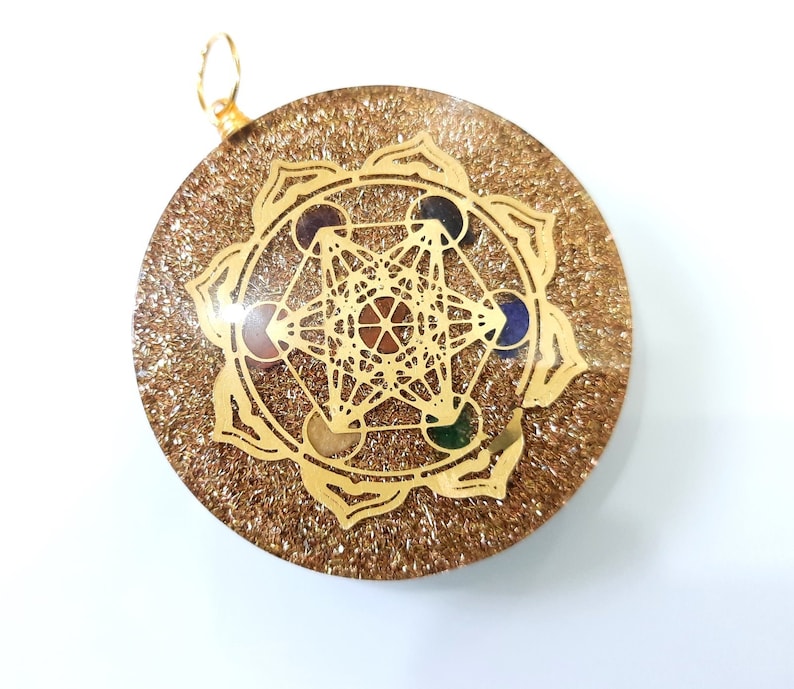 May include: Gold-toned pendant with a clear resin background and a gold geometric design with seven colorful gemstones. The pendant is surrounded by a gold flower design.