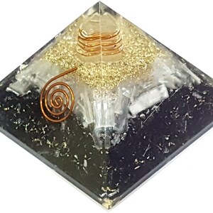 May include: A black, white, and gold crystal pyramid with a copper wire spiral on top. The pyramid is made of clear resin and has a layered design.