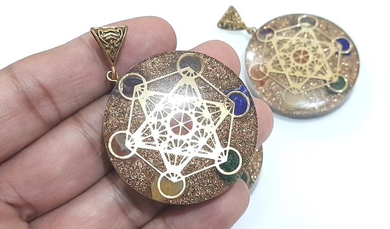 Pu&ograve; includere: Ciondolo in oro con un design in resina trasparente che presenta un motivo geometrico e sette pietre colorate. Il ciondolo &egrave; su una catena d'oro.