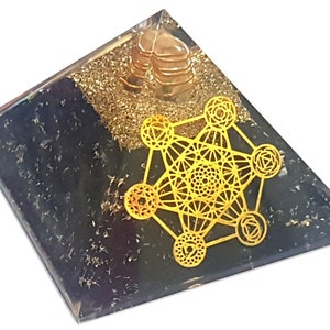 May include: A clear crystal pyramid with a gold metallic geometric design and black obsidian at the base. The pyramid is approximately 2 inches tall.