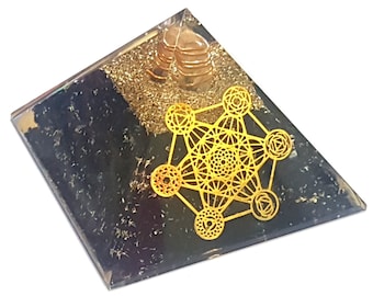May include: A clear crystal pyramid with a gold metallic geometric design and black obsidian at the base. The pyramid is approximately 2 inches tall.