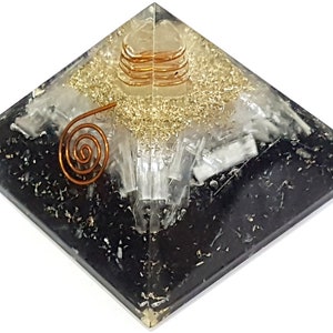 May include: Black obsidian pyramid with a clear quartz crystal and gold flecks. A copper wire coil is embedded in the center of the pyramid.