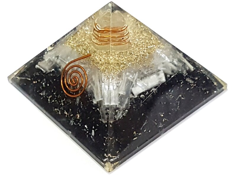 May include: Black obsidian pyramid with a clear quartz crystal and gold flecks. A copper wire coil is embedded in the center of the pyramid.