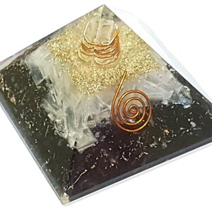 May include: A black and white crystal pyramid with a gold and copper wire spiral on top. The pyramid is made of clear glass and has a black base.