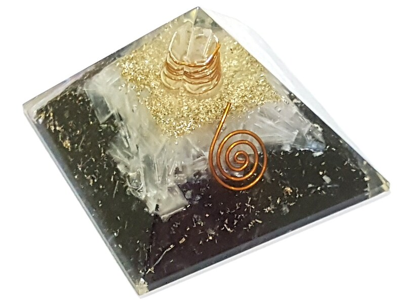 May include: A black and white crystal pyramid with a gold and copper wire spiral on top. The pyramid is made of clear glass and has a black base.