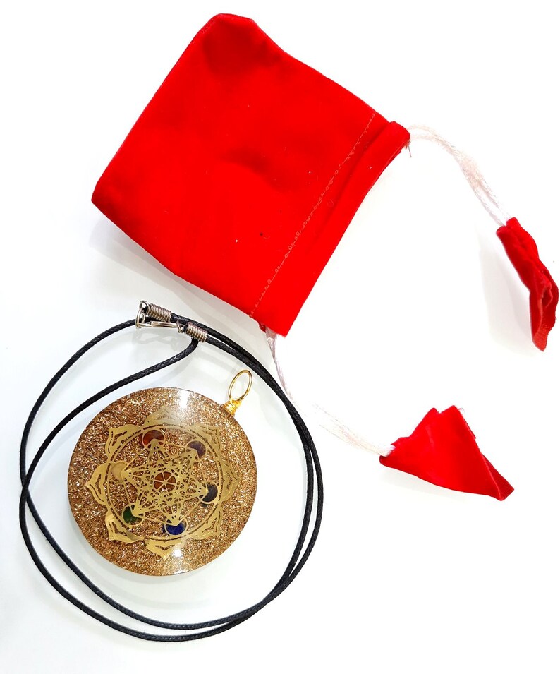 May include: A gold-colored pendant with a geometric design and seven colored stones, on a black cord, with a red velvet pouch.