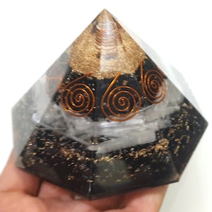 Op de afbeelding: Zwarte obsidiaan piramide met koperen draadspiralen en heldere kwartskristallen. De piramide is ongeveer 5 cm hoog.