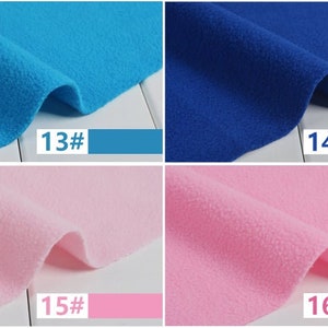 May include: Close-up of four swatches of fleece fabric in shades of blue and pink. The colors are labeled with numbers and color swatches: 13# turquoise, 14# royal blue, 15# light pink, and 16# medium pink. The fabric has a soft, textured appearance.
