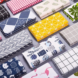 May include: A collection of folded fabric squares with various patterns, including geometric designs, animals, and plants. The fabrics are in a variety of colors, including red, blue, yellow, green, and white.